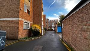 an empty alley between two brick buildings at Cozy 2 Bedroom Apartment close to Town Centre in Woking