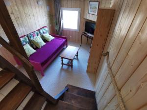einen Blick über ein Wohnzimmer mit einem lila Sofa in der Unterkunft Le Pigeonnier de Bouheben in Verlus