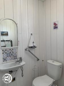 La salle de bains est pourvue de toilettes, d'un lavabo et d'un miroir. dans l'établissement Le Pigeonnier de Bouheben, à Verlus