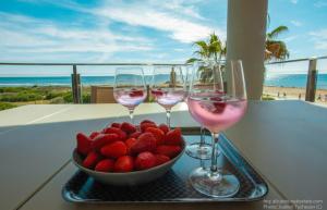 trzy kieliszki wina i truskawki na tacy na balkonie w obiekcie 31 Luxury Beautiful Holiday w mieście La Mata