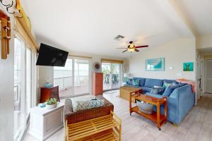 uma sala de estar com um sofá azul e uma televisão em Amada Grenada em Summerland Key
