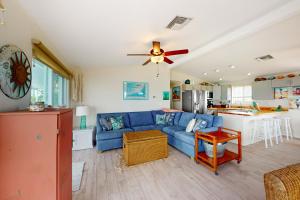 a living room with a blue couch and a kitchen at Amada Grenada in Summerland Key