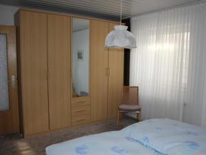 a bedroom with a bed and a chair and a mirror at Riedel Fronz in Lennestadt