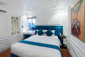 a bedroom with a large bed with a blue headboard at Diamond Hotel Sapa in Sa Pa