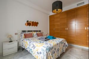 1 dormitorio con 1 cama y armarios de madera en Apartamento Moderno Con Wifi Gratis, en Sevilla