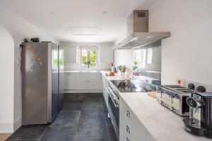 a kitchen with white cabinets and a stainless steel refrigerator at Neptune House in Wells next the Sea