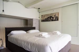 a bedroom with a large white bed with towels on it at Youhosty - Lambro12 in Milan