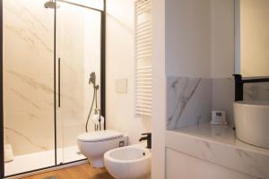 a white bathroom with a toilet and a sink at Youhosty - Lambro12 in Milan +5 photos