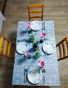 uma mesa com pratos brancos e rosas cor-de-rosa em Lavender Vendégház Kicsi falu nagy szívvel varázslatos légkörrel em Golop
