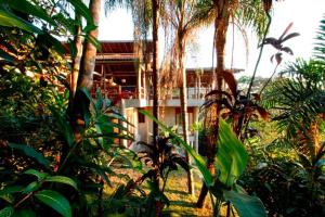 een resort met palmbomen en een gebouw op de achtergrond bij 5 suítes-Cond. fechado- Vista para a Barra do Sahy in São Sebastião