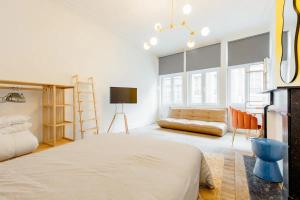 a bedroom with a large bed and a couch at Le Studio en Feronstrée in Liège