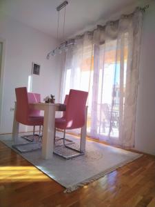 a dining room with pink chairs and a table at Apartman Natasha in Trebinje