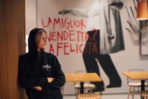 a woman standing in a room with her arms crossed at The Poet Hotel in La Spezia