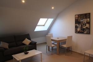 a living room with a couch and a table at AR Apartamentos Soto Del Real in Soto del Real