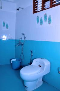 a blue bathroom with a toilet and a shower at The Banyan Tree Samudra in Kovalam