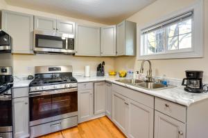 a kitchen with white cabinets and a stove and a sink at Charming Boho Home Near OSU, Short North, Downtown in Columbus