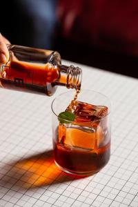 a bottle of whiskey being poured into a drink at Hotel Royal Continental in Naples