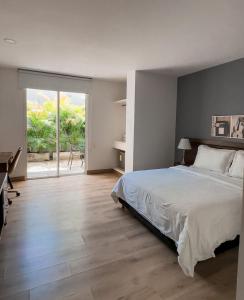 a bedroom with a bed and a sliding glass door at Malik Hotel Boutique in Cali