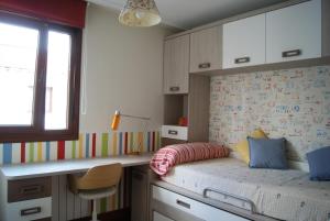 a small bedroom with a bed and a desk at BEC, Hospital Cruces, parking gratis, wifi, AA, a 15 min de Bilbao in Barakaldo