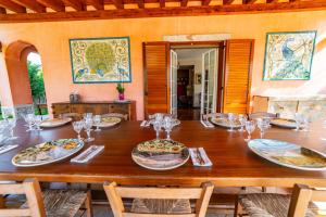 a large wooden table with plates and glasses on it at Villa Rita Taormina in Taormina