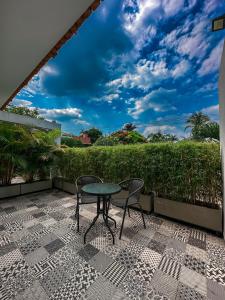 a patio with two chairs and a table on a balcony at Malik Hotel Boutique in Cali