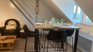 uma mesa de jantar com cadeiras e copos em Katy's Home Dinard em Dinard