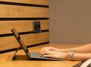 a woman sitting at a table using a laptop computer at RK Farallón Canteras in Las Palmas de Gran Canaria