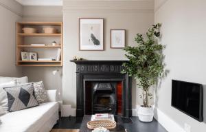 un soggiorno con camino e divano bianco di The Leicester Square Apartment By Hok Living a Londra