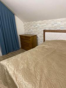 1 dormitorio con 1 cama, vestidor y cortinas azules en Апартаменты en Vínnytsia