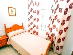 een kleine slaapkamer met een bed en een raam bij Apartamentos Noria Familias y Parejas Gold in Conil de la Frontera