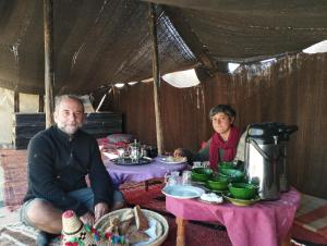 a man and woman sitting at a table in a tent at Auberge Palacio Sidi Hamza in Tazrouft