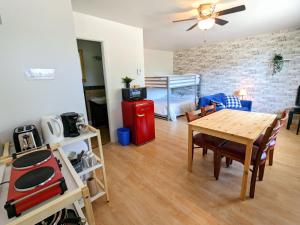 ein Wohnzimmer mit einem Tisch und ein Schlafzimmer in der Unterkunft Les Petits Studios du bord de l'eau in Saint-Joseph-de-la-Rive
