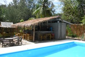 Cabaña pequeña con mesa, sillas y piscina en DolceVita Wonderful Resort en Ko Lanta