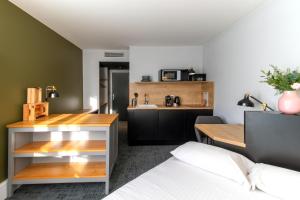 Pokój z łóżkiem i kuchnią w obiekcie Le Parc 42 Saint-Etienne w mieście Saint-Étienne