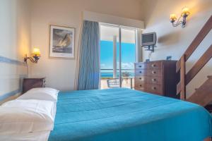 een slaapkamer met een groot bed met een blauwe deken bij Villa Amelia in Falésia by the Sea in Caniço +46 foto's