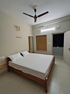 - une chambre avec un lit et un ventilateur de plafond dans l'établissement SN Residency, à Kalpatta