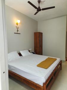 a bedroom with a bed with a ceiling fan at SN Residency in Kalpetta
