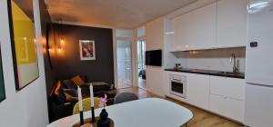 una cocina con armarios blancos y una mesa blanca en una habitación en Modern, fully equipped flat en Copenhague