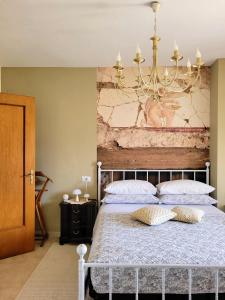 - une chambre avec un grand lit et un lustre dans l'établissement Porta Pompei & Sorrento Coast, à Castellammare di Stabia