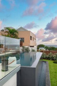 une maison avec une piscine en face d'une maison dans l'établissement VILLA KARAMISO - Piscine à débordement & Vue sur mer - Accès Plage, à Saint-François