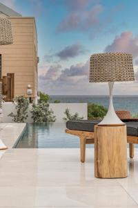 une lampe assise sur une table à côté d'une piscine dans l'établissement VILLA KARAMISO - Piscine à débordement & Vue sur mer - Accès Plage, à Saint-François