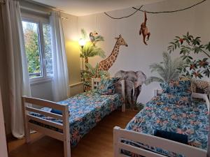 Cette chambre comprend deux lits, une girafe et un éléphant. dans l'établissement Les Volets Bleus, à Rungis