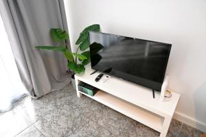 a flat screen tv sitting on a white tv stand at Homenfun Barcelona Bellvitge in Hospitalet de Llobregat
