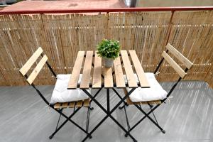 une table et deux chaises avec une plante en pot dans l'établissement Homenfun Barcelona Bellvitge, à L'Hospitalet de Llobregat