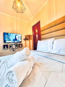 1 dormitorio con 1 cama con toallas en Cozy BNB - Unit E, en Batangas