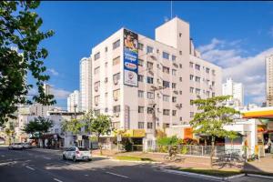 a large white building on the side of a city street at Residencial Primavera in Balneário Camboriú