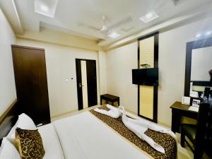 - une chambre avec un lit, un bureau et une télévision dans l'établissement Blueberry Nest Zirakpur, à Zirakpur