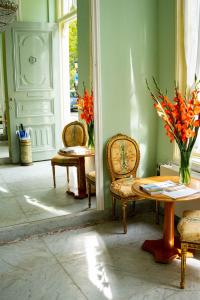 a room with two chairs and a table with a vase of flowers at Boutique Hotel Museumkwartier in Utrecht