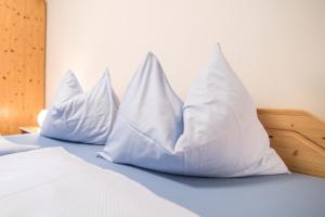 two pillows sitting on top of a bed at Rieplhof - Relaxing farm stay with breakfast and mountain view in Vipiteno