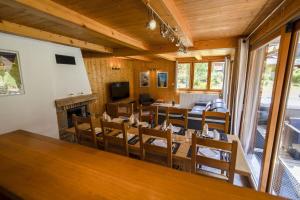 Chalet Haut Fort Ski Injacuzzi في مورزين: غرفة طعام مع طاولة وكراسي ومدفأة